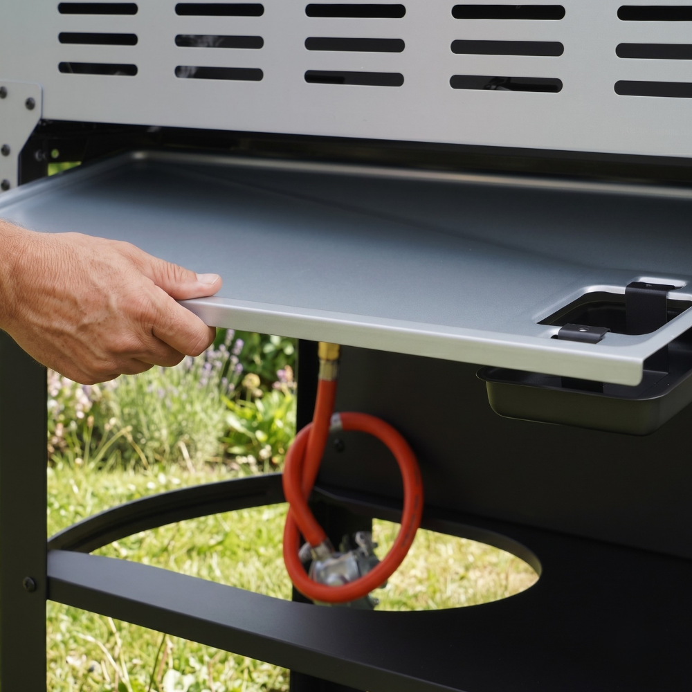 Removing the drip tray from behind a gas grill outdoor